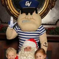 Alumni's two children posing with Santa and Louie the Laker